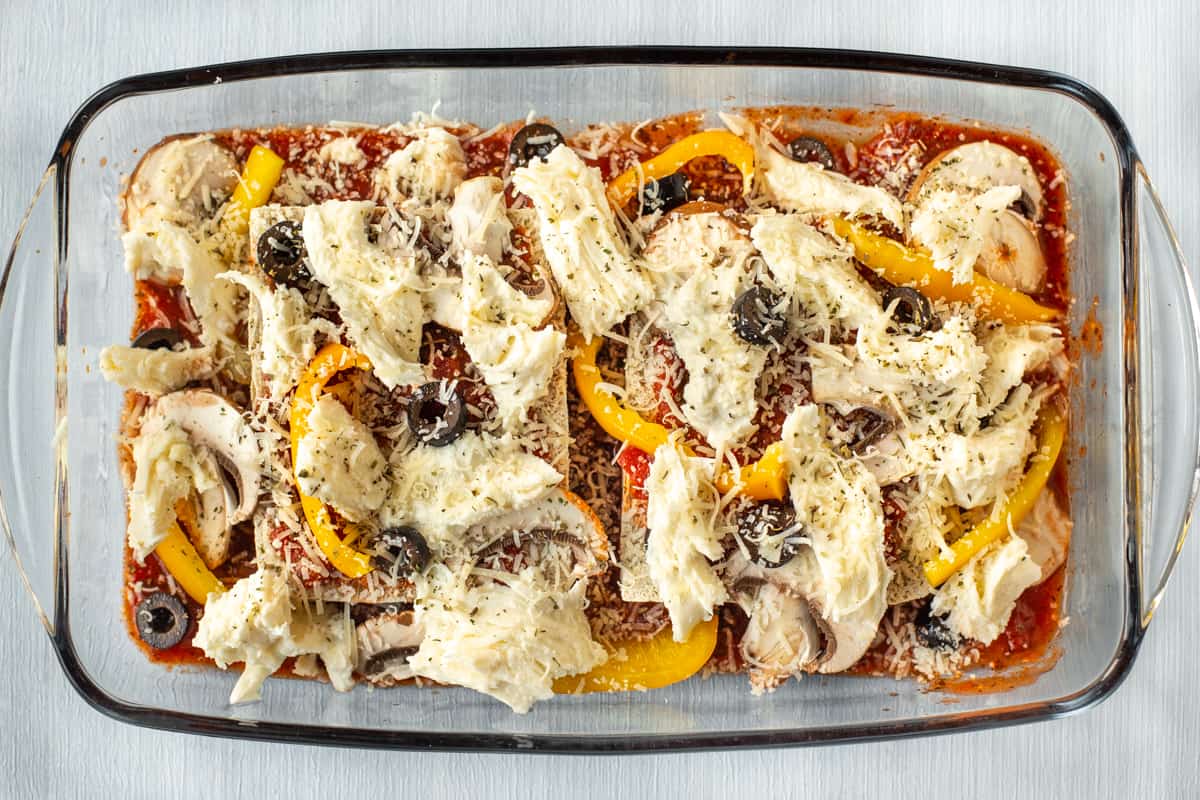 Uncooked pizza topped tofu in a baking dish.