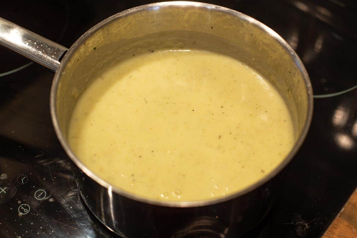 Creamy potato and spring onion soup in a saucepan.