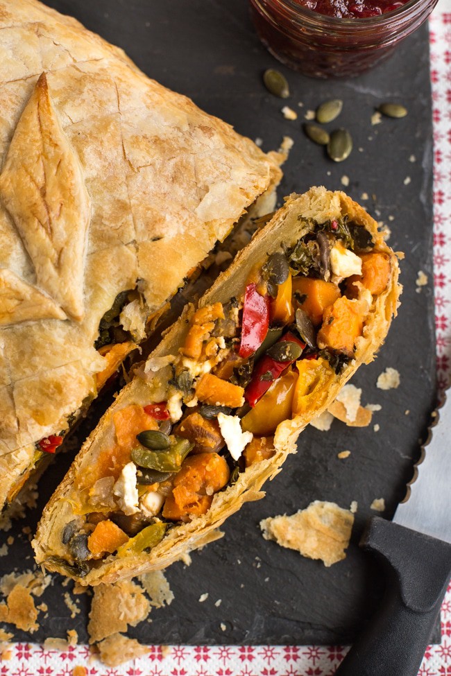 Vegetarian roasted veggie en croute on a slate board with a slice cut off