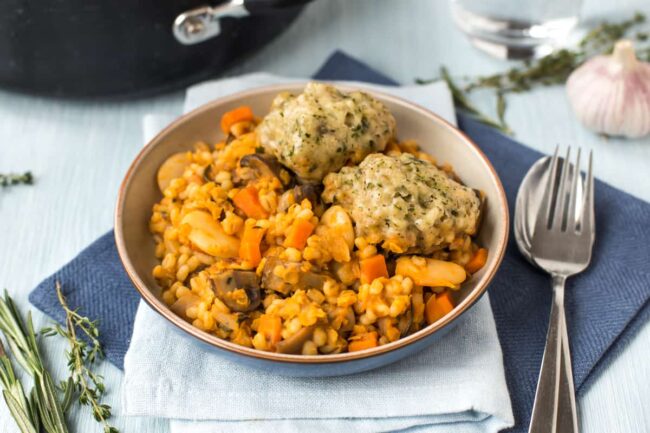 A portion of vegan cassoulet in a bowl with herbed dumplings.