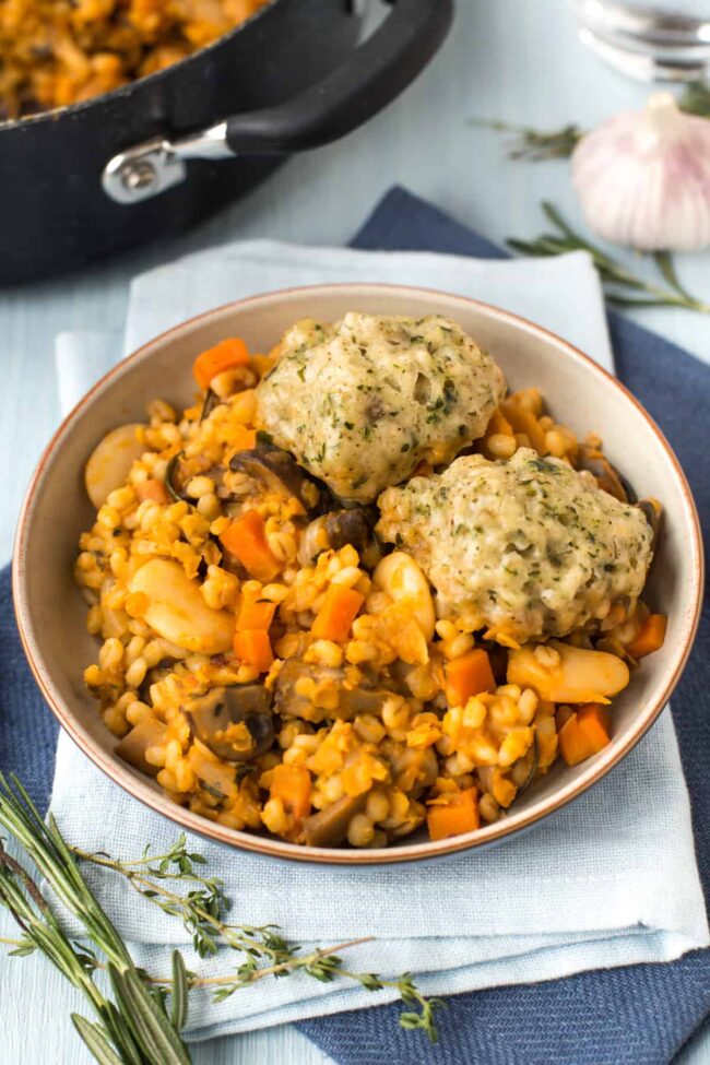 Bowlful of vegan cassoulet with herby dumplings, beans and pearl barley.