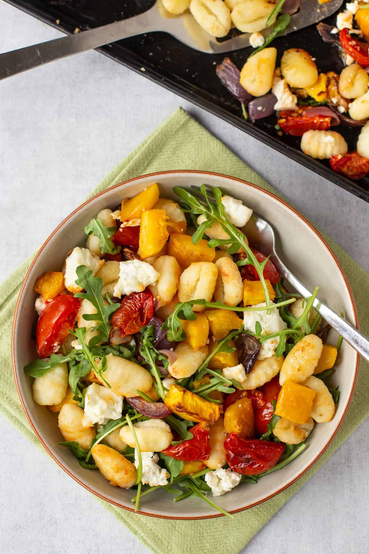 Overhead shot of a portion of gnocchi with pumpkin and roasted tomatoes.