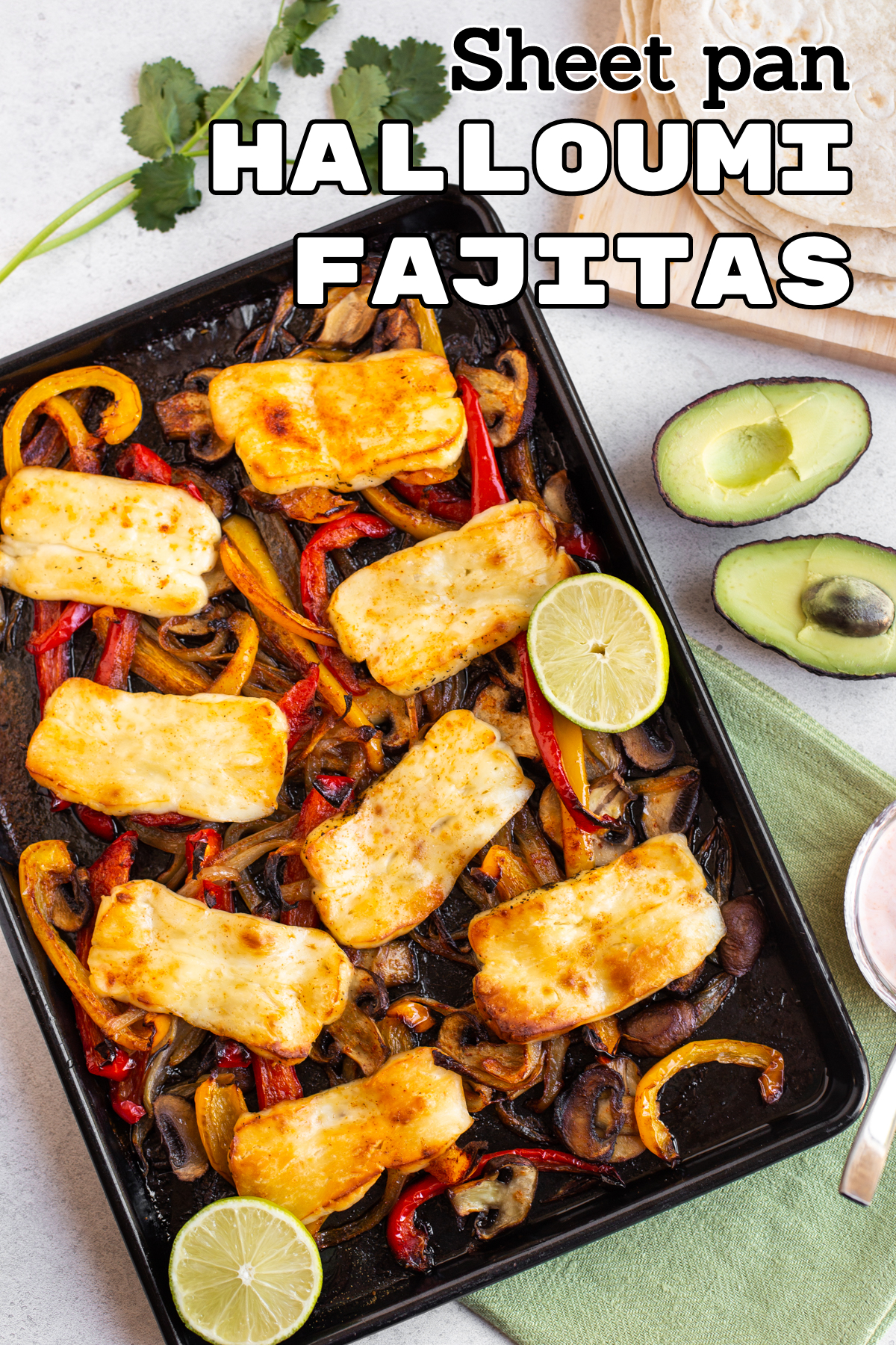 Roasted vegetables and halloumi on a baking tray.