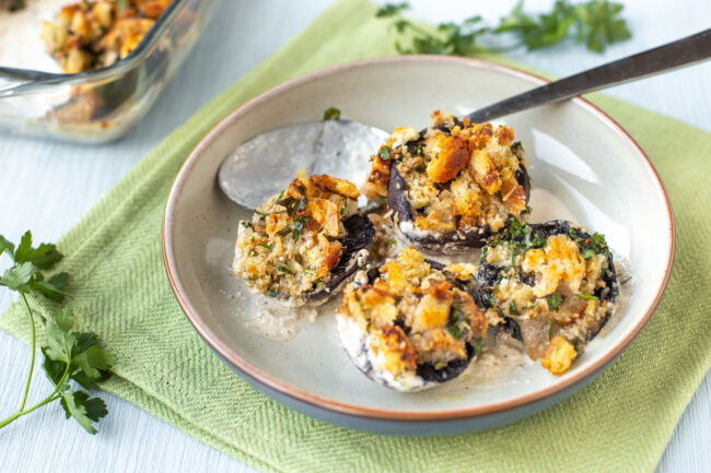 4 crispy stuffed mushrooms in a bowl with a spoon.