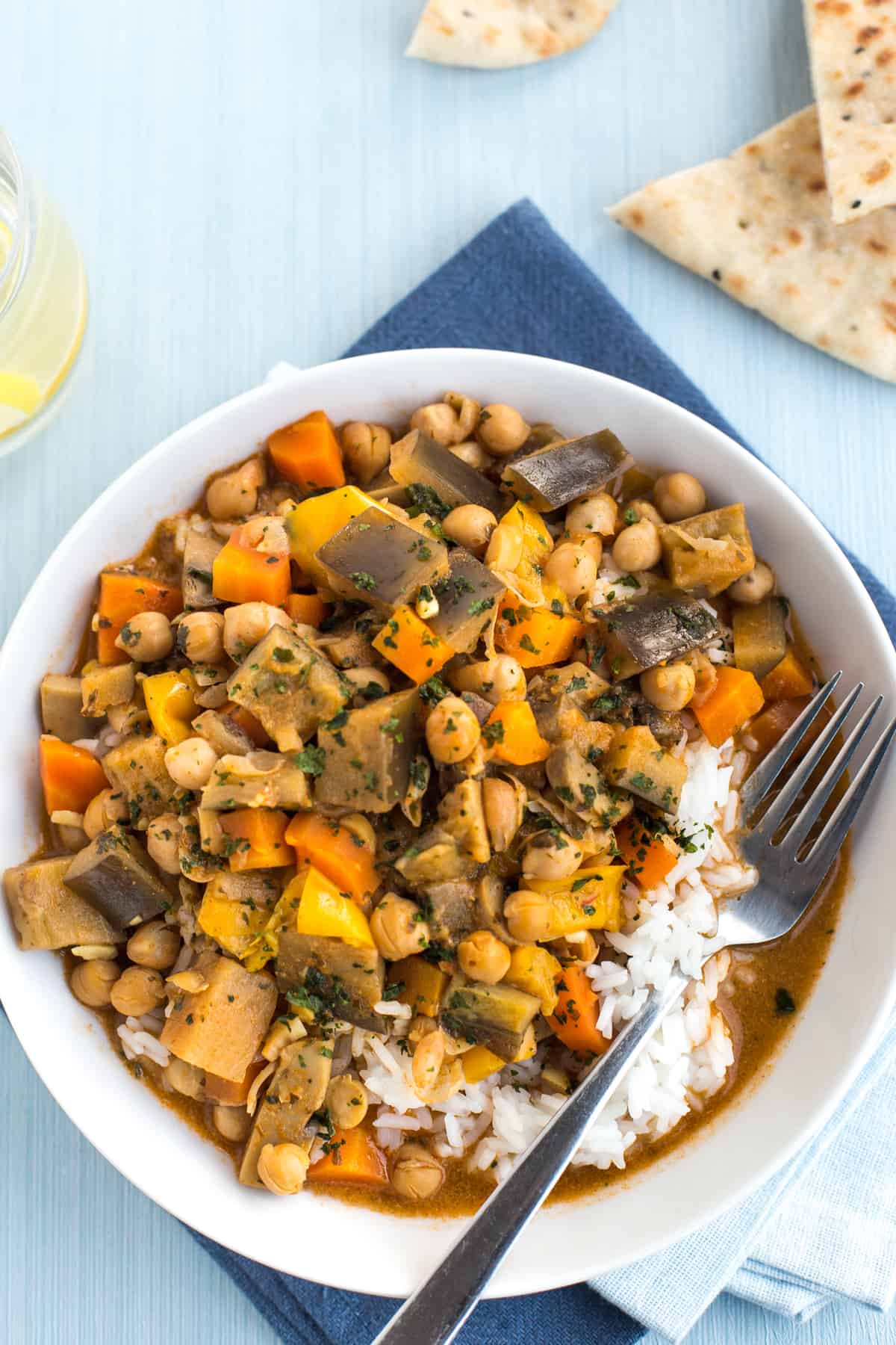 Portion of chickpea curry and rice in a bowl with a fork.