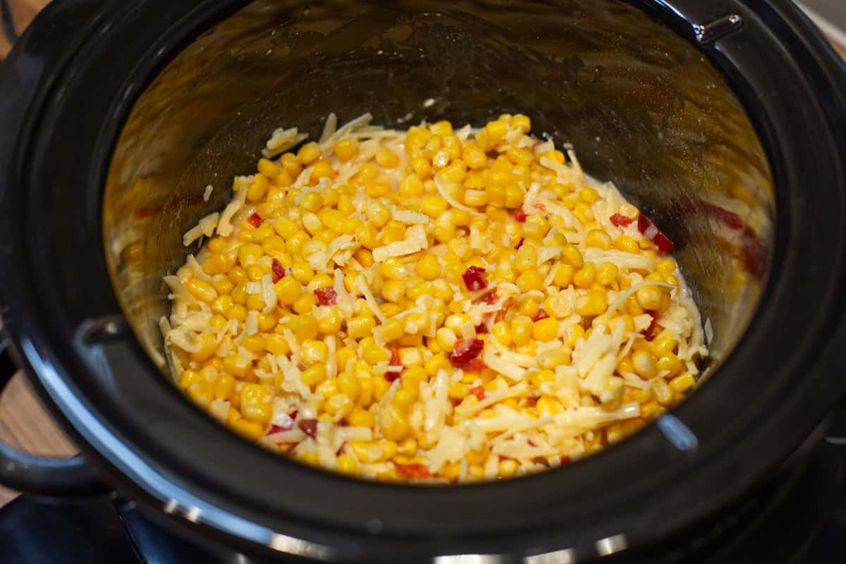 Uncooked ingredients for slow cooker corn casserole in a pot.