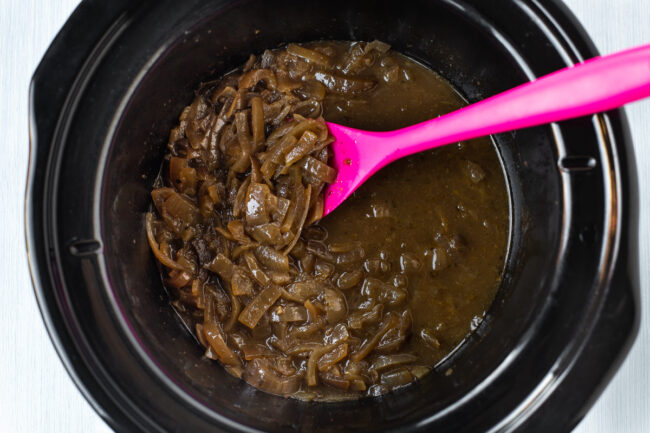Rich slow cooked French onion soup in a pot.