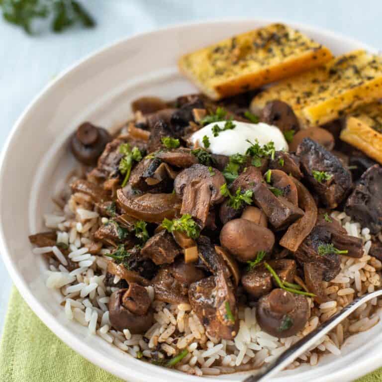 Mushroom stroganoff in a bowl with rice and parsley.