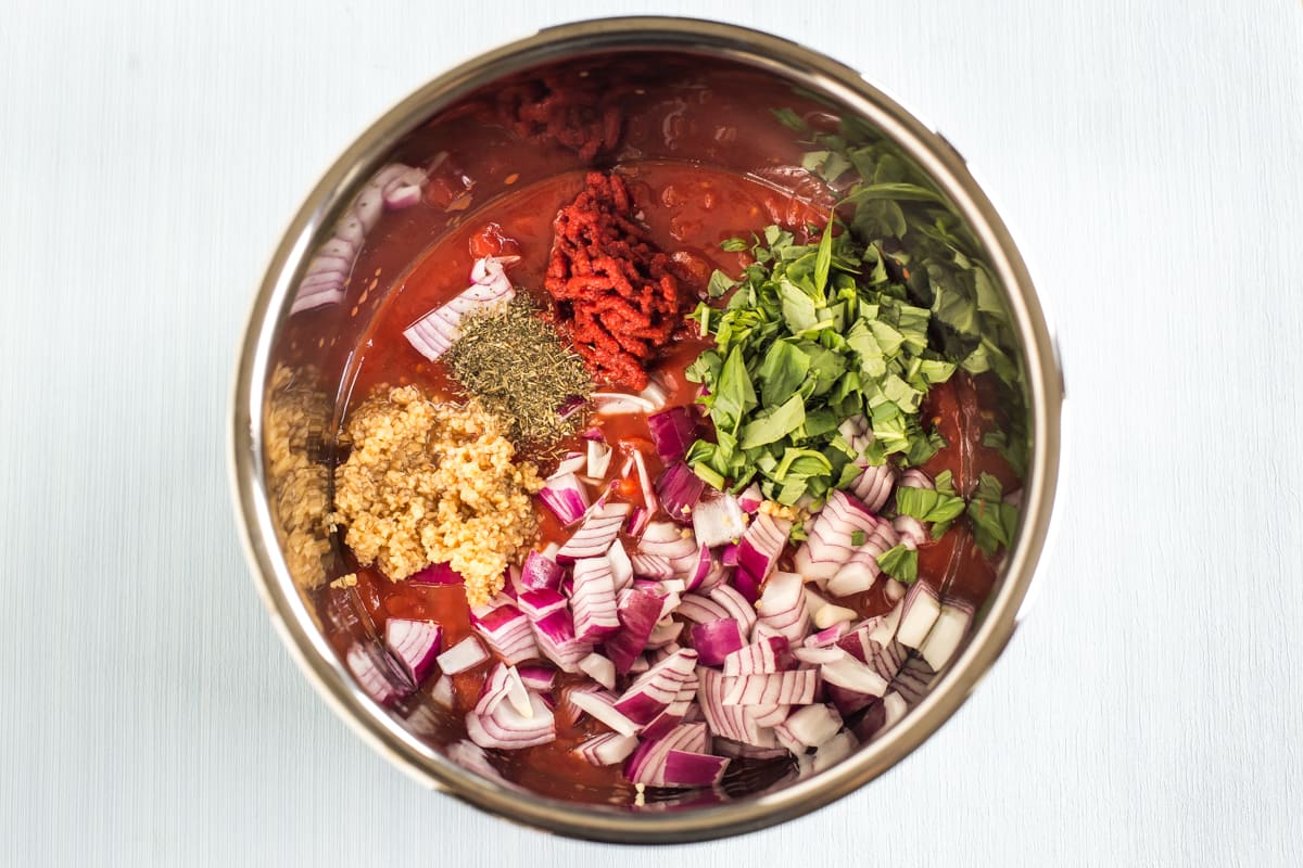 Raw ingredients for slow cooker tomato sauce in the pot.