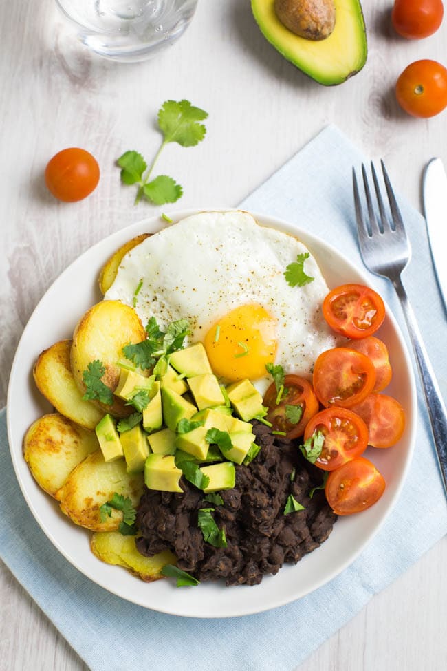 Smoky black bean breakfast bowls! Spicy chipotle black beans, served with crispy potatoes, a fried egg, and lots of fresh veggies - a brilliant way to start the day! Vegetarian, gluten-free, and easily made vegan.