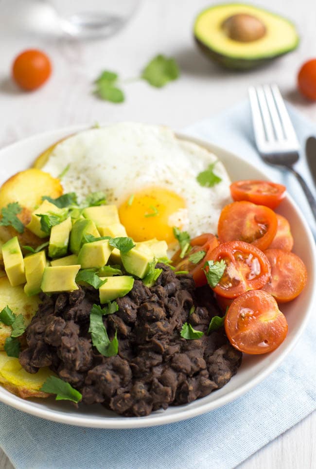 Smoky black bean breakfast bowls! Spicy chipotle black beans, served with crispy potatoes, a fried egg, and lots of fresh veggies - a brilliant way to start the day! Vegetarian, gluten-free, and easily made vegan.