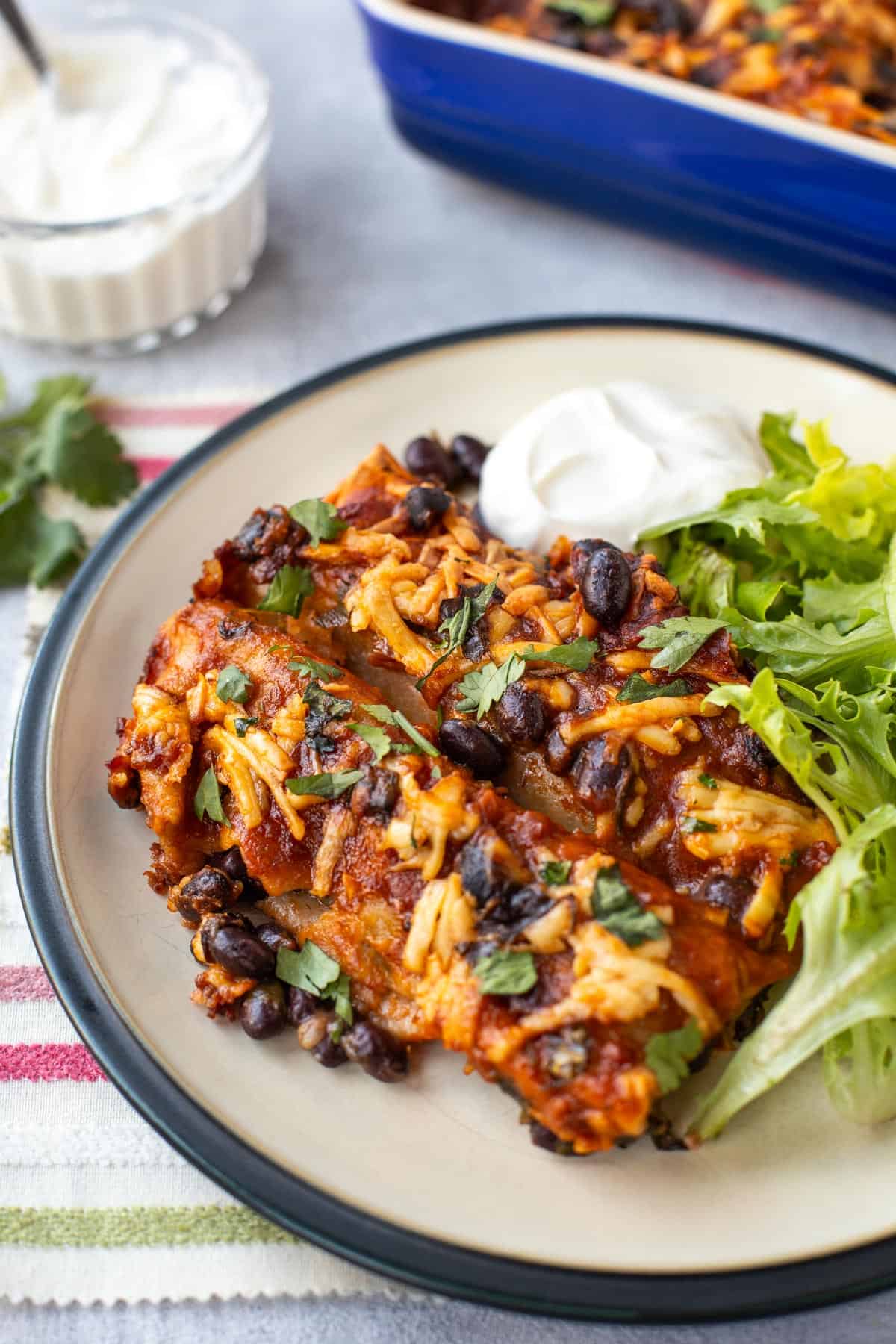A portion of spinach and black bean enchiladas on a plate.