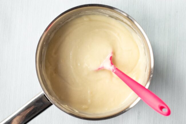 A creamy white sauce in a saucepan.