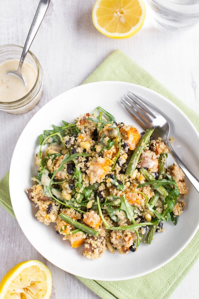 A colourful quinoa and sweet potato salad on a white plate.