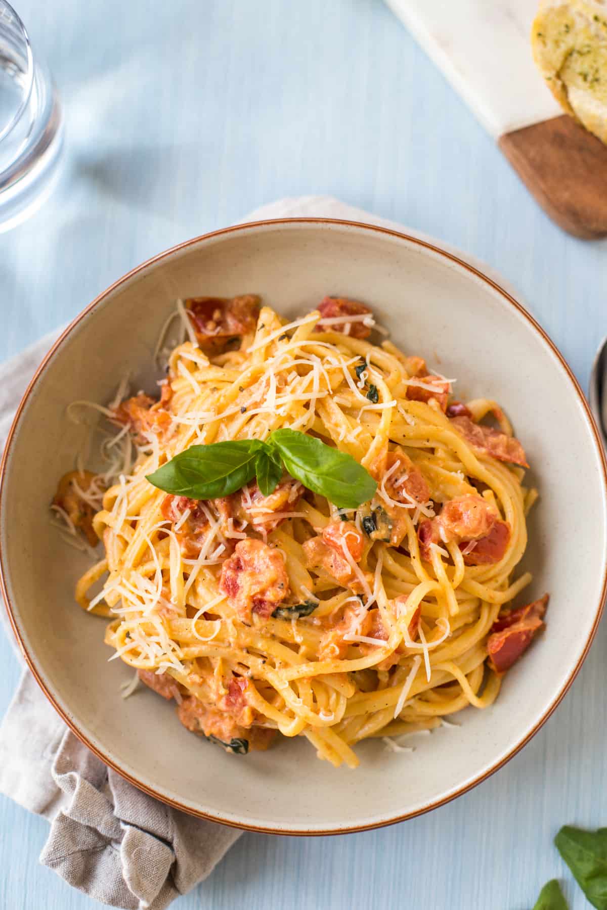 Pasta in tomato mascarpone sauce, in a bowl with fresh basil.