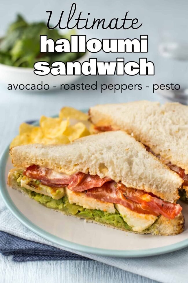 A halloumi and red pepper sandwich on a plate with some potato chips.