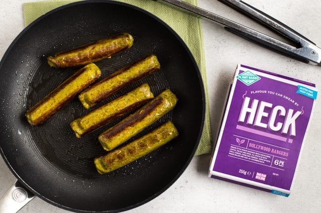 Heck Bollywood Bangers vegan sausages cooked in a frying pan