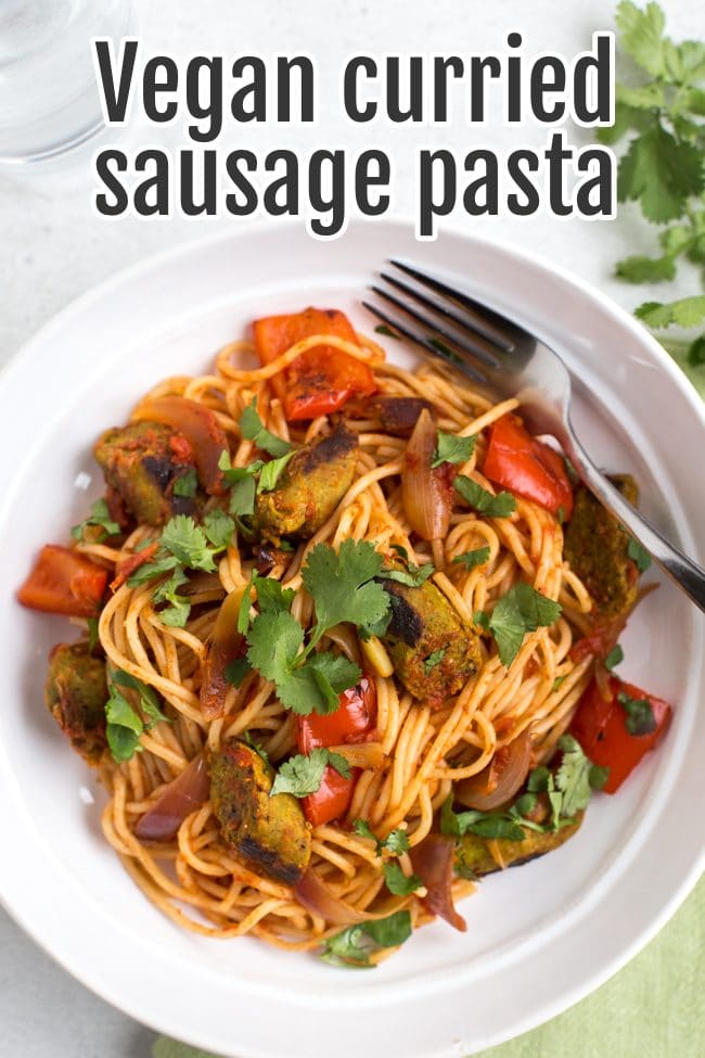 Portion of vegan curried sausage pasta in a bowl topped with cilantro
