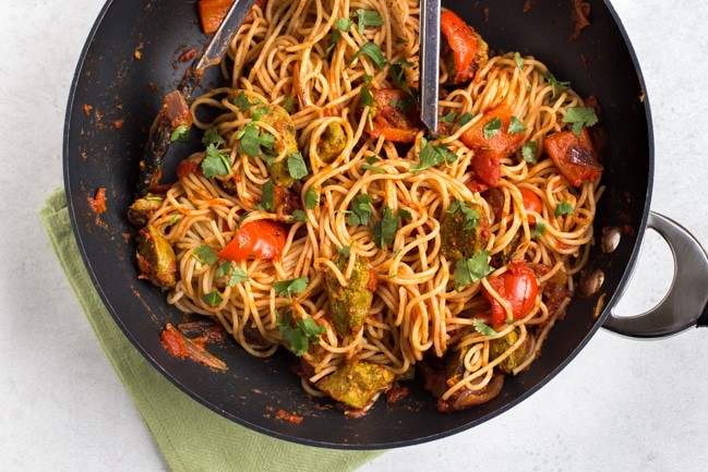 Vegan curried sausage pasta in a large wok
