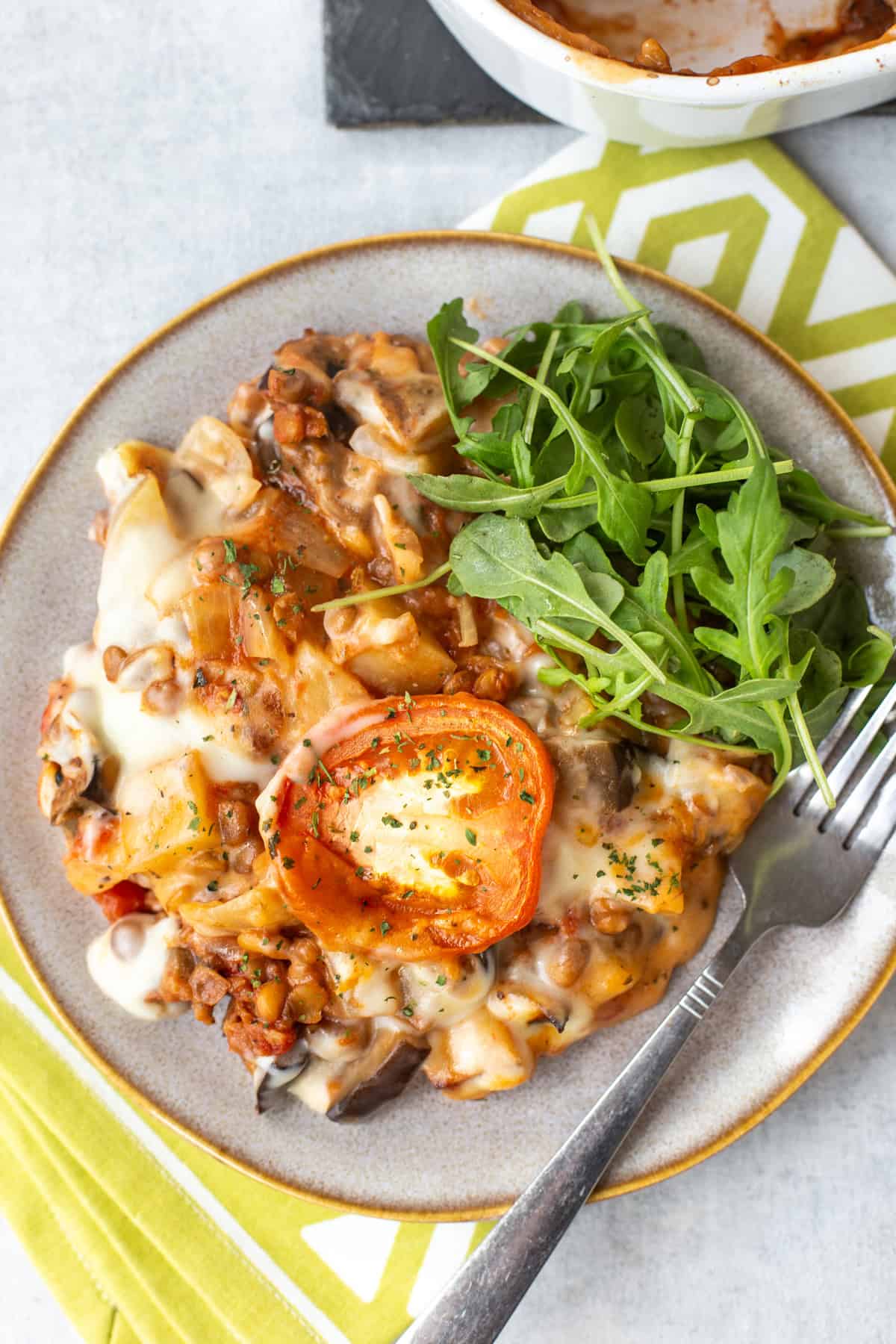 Overhead shot of a portion of vegetable moussaka with salad.