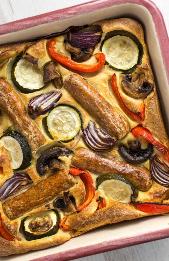 Vegetable toad in the hole - vegetarian sausages and roasted veggies, all cooked in a Yorkshire pudding batter. A classic British recipe!