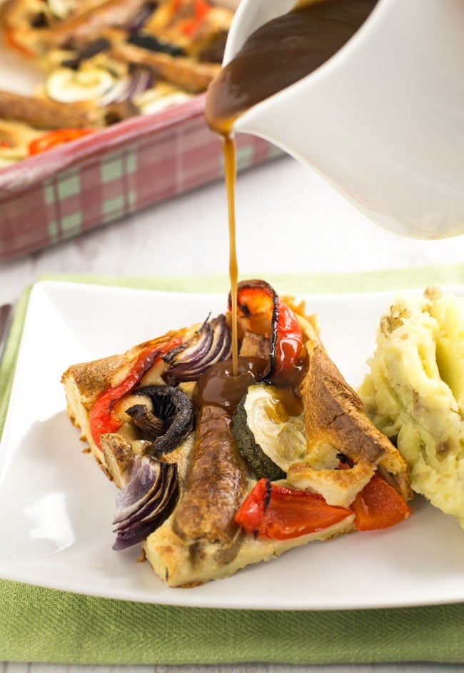 Vegetable toad in the hole - vegetarian sausages and roasted veggies, all cooked in a Yorkshire pudding batter. A classic British recipe!