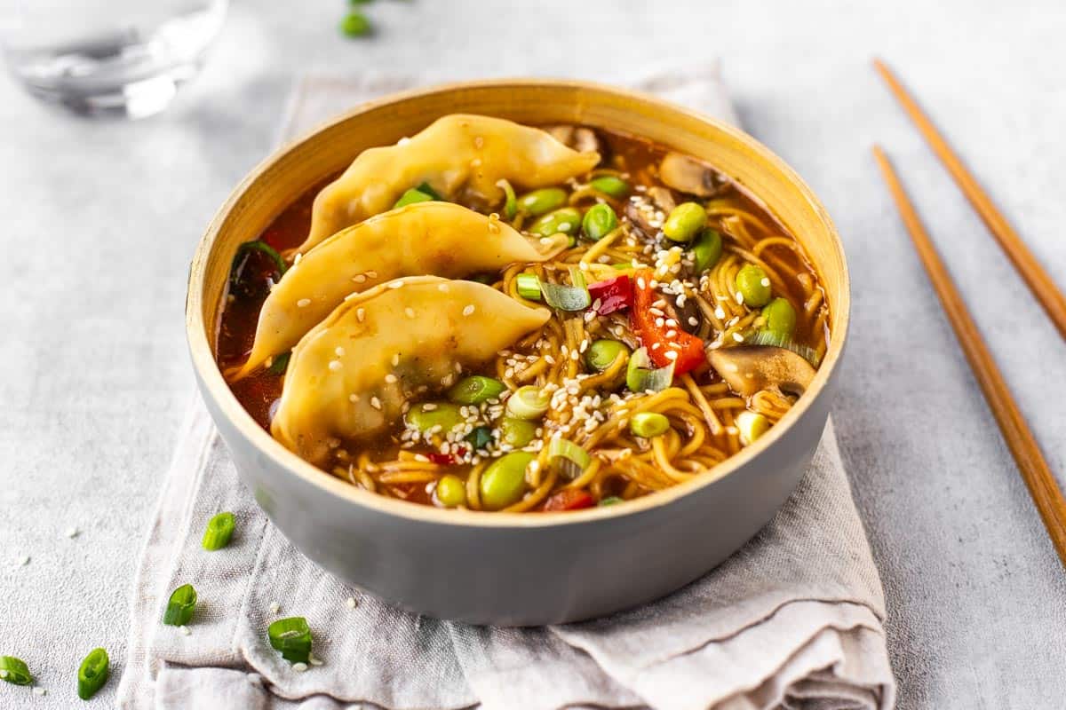 A bowlful of vegetable gyoza soup with noodles.