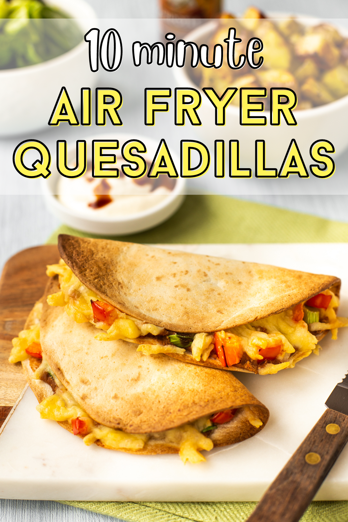 Two crispy quesadillas stacked up on a board.